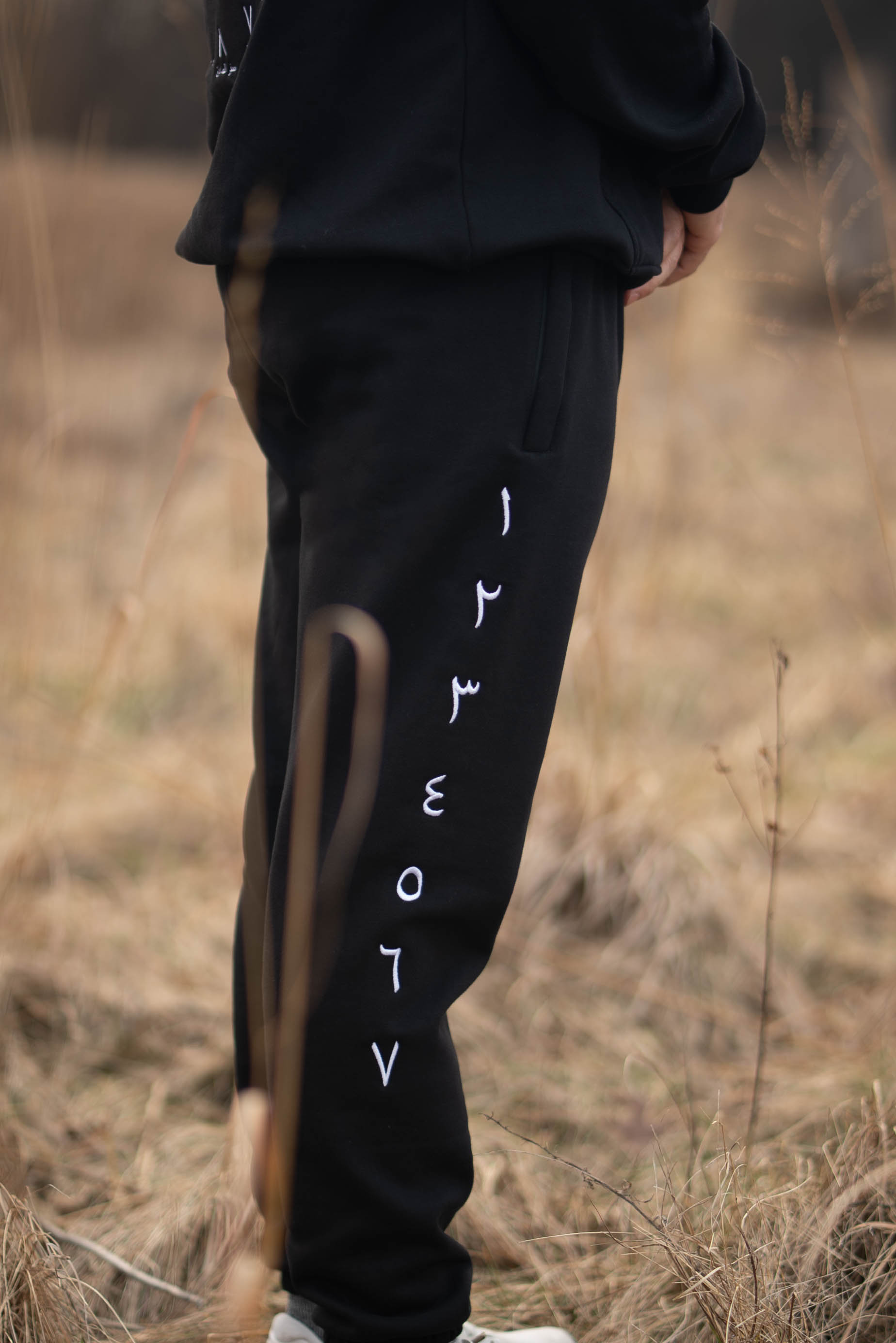 Original close-up of white Arabic numerals running vertically down black sweatpants