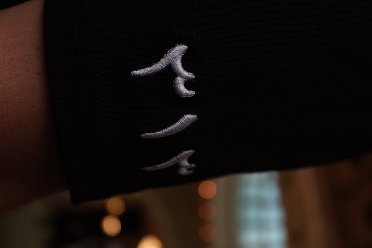 Macro view of embroidered Arabic numerals on the 40 Nights tee